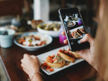 crop woman taking shot of food on mobile phone during lunch