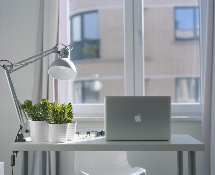 silver macbook air and goose neck lamp