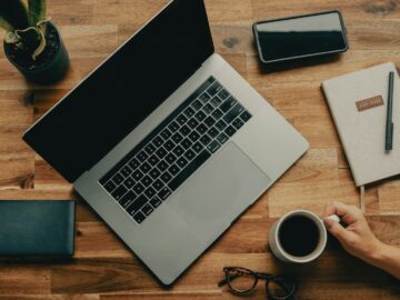 macbook pro beside black iphone 5 on brown wooden table