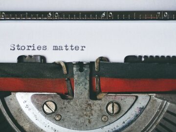 Close-up of a vintage typewriter with the text 'Stories matter' typed on paper, evoking nostalgia.