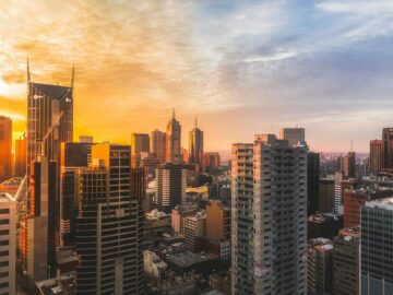 Stunning view of Melbourne's skyline at sunset, capturing modern skyscrapers and warm sky.