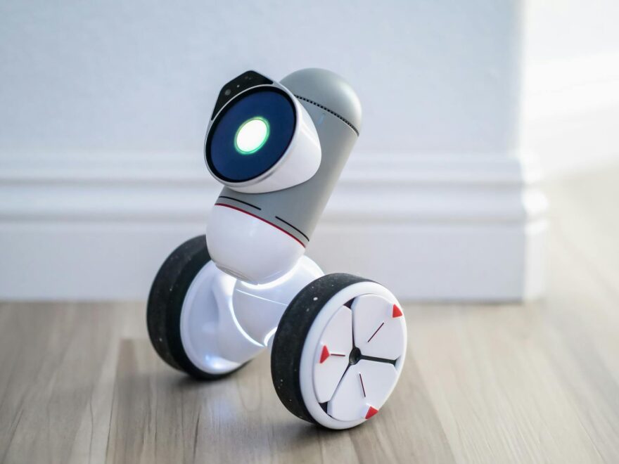 Close-up of a ClicBot toy robot on wheels indoors, highlighting its modern design and technology.