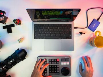 a person typing on a keyboard next to a laptop